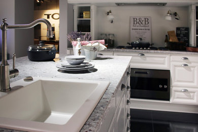 Große Klassische Küche in U-Form mit Waschbecken, profilierten Schrankfronten, weißen Schränken, Granit-Arbeitsplatte, Kücheninsel und grauer Arbeitsplatte in Sonstige