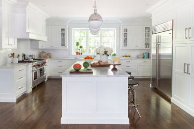 Eat-in kitchen - large transitional l-shaped dark wood floor eat-in kitchen idea in New York with an undermount sink, shaker cabinets, white cabinets, marble countertops, white backsplash, subway tile backsplash, stainless steel appliances and an island
