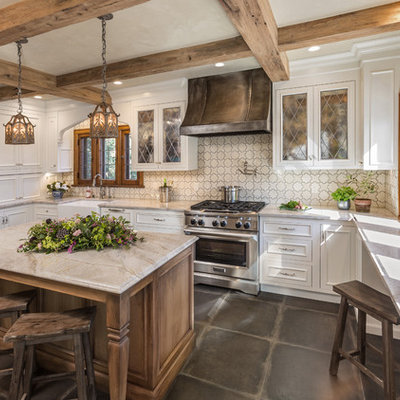 Enclosed kitchen - mid-sized traditional u-shaped gray floor and porcelain tile enclosed kitchen idea in Milwaukee with a farmhouse sink, recessed-panel cabinets, white cabinets, an island, marble countertops, white backsplash, cement tile backsplash, paneled appliances and multicolored countertops