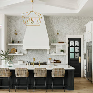 Immagine di un'ampia cucina chic con lavello sottopiano, ante in stile shaker, ante bianche, paraspruzzi grigio, elettrodomestici in acciaio inossidabile, parquet chiaro, isola, top in quarzo composito, paraspruzzi in marmo e pavimento beige