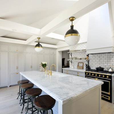 Transitional galley medium tone wood floor eat-in kitchen photo in Ottawa with recessed-panel cabinets, gray cabinets, marble countertops, white backsplash, subway tile backsplash, black appliances, an island and an undermount sink