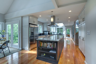Inspiration for a large transitional l-shaped medium tone wood floor eat-in kitchen remodel in Boston with an undermount sink, shaker cabinets, gray cabinets, granite countertops, stainless steel appliances and an island
