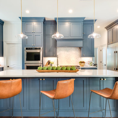 Example of a large transitional l-shaped medium tone wood floor and brown floor open concept kitchen design in Dallas with an undermount sink, shaker cabinets, blue cabinets, marble countertops, gray backsplash, marble backsplash, stainless steel appliances, an island and white countertops