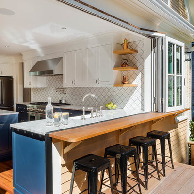 Mid-sized trendy l-shaped medium tone wood floor and brown floor eat-in kitchen photo in Boston with a farmhouse sink, recessed-panel cabinets, white cabinets, quartzite countertops, white backsplash, porcelain backsplash, stainless steel appliances and an island