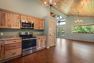 Inspiration for a large rustic u-shaped laminate floor and brown floor eat-in kitchen remodel in Other with a double-bowl sink, recessed-panel cabinets, light wood cabinets, granite countertops, multicolored backsplash, stainless steel appliances, no island and multicolored countertops