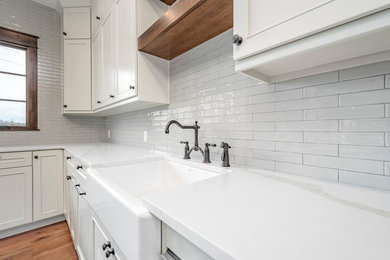 Example of a farmhouse kitchen design in Other with gray backsplash and subway tile backsplash