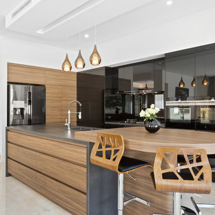 Design ideas for a contemporary l-shaped kitchen in Perth with a double-bowl sink, flat-panel cabinets, medium wood cabinets, wood benchtops, stainless steel appliances, with island, beige floor and brown benchtop.