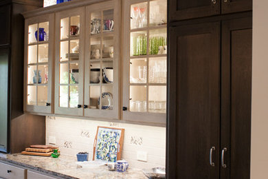 ウィチタにあるトラディショナルスタイルのおしゃれなアイランドキッチン (レイズドパネル扉のキャビネット、シルバーの調理設備、濃色無垢フローリング) の写真