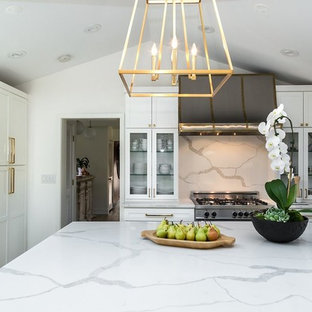 Large transitional kitchen photos - Example of a large transitional l-shaped light wood floor and brown floor kitchen design in Chicago with an undermount sink, shaker cabinets, white cabinets, quartz countertops, gray backsplash, marble backsplash, stainless steel appliances and an island