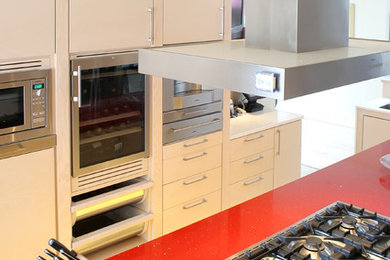 Imagen de cocina industrial con armarios con paneles lisos, puertas de armario beige, encimera de cuarzo compacto y electrodomésticos de acero inoxidable