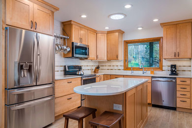 Mid-sized elegant u-shaped porcelain tile and multicolored floor eat-in kitchen photo in Other with an undermount sink, shaker cabinets, medium tone wood cabinets, quartz countertops, white backsplash, ceramic backsplash, stainless steel appliances, an island and white countertops