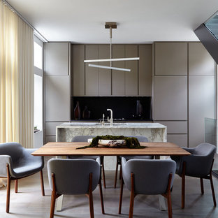 Mid-sized modern galley eat-in kitchen in New York with an undermount sink, flat-panel cabinets, grey cabinets, marble benchtops, black splashback, stone slab splashback, stainless steel appliances, with island, brown floor, multi-coloured benchtop and dark hardwood floors.