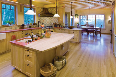 Eat-in kitchen - large cottage u-shaped light wood floor and beige floor eat-in kitchen idea in Boston with a drop-in sink, light wood cabinets, multicolored backsplash, ceramic backsplash, stainless steel appliances, an island, shaker cabinets and wood countertops