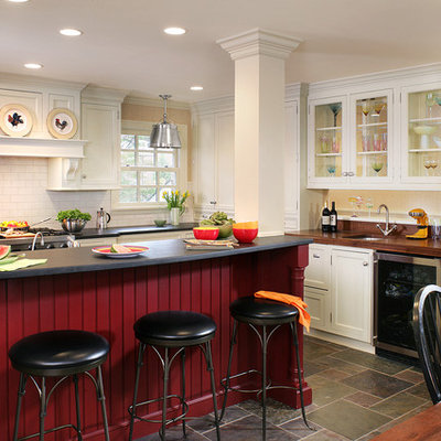 Elegant eat-in kitchen photo in Newark with stainless steel appliances, an undermount sink, wood countertops, glass-front cabinets and white cabinets