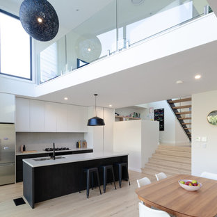 Design ideas for a mid-sized contemporary galley open plan kitchen in Sydney with an undermount sink, flat-panel cabinets, quartz benchtops, grey splashback, stone slab splashback, light hardwood floors, with island, grey benchtop, stainless steel appliances, beige floor and dark wood cabinets.