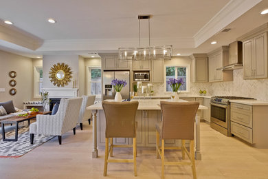 Example of a mid-sized classic l-shaped light wood floor open concept kitchen design in San Francisco with an undermount sink, beaded inset cabinets, beige cabinets, solid surface countertops, beige backsplash, stone tile backsplash, stainless steel appliances and an island