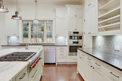 Offene, Große Klassische Küche in L-Form mit Landhausspüle, Schrankfronten im Shaker-Stil, weißen Schränken, braunem Holzboden und Kücheninsel in New Orleans
