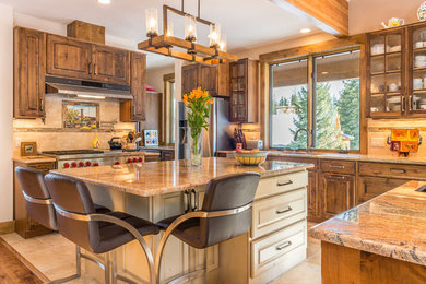 Inspiration for a large rustic u-shaped eat-in kitchen remodel in Denver with an undermount sink, raised-panel cabinets, medium tone wood cabinets, granite countertops, stainless steel appliances and an island