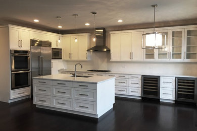 Inspiration for a large transitional l-shaped dark wood floor open concept kitchen remodel in Chicago with an undermount sink, shaker cabinets, white cabinets, quartzite countertops, white backsplash, subway tile backsplash, stainless steel appliances and an island