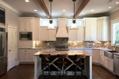 Example of a classic light wood floor kitchen design in Atlanta with a farmhouse sink, shaker cabinets, white cabinets, granite countertops, stainless steel appliances and an island