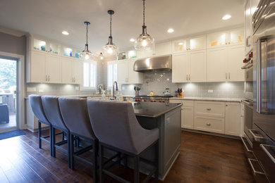 Kitchen - u-shaped kitchen idea in Chicago with shaker cabinets, white cabinets, stainless steel appliances and an island