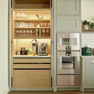Imagen de cocina clásica renovada, grande, con encimera de cuarcita, salpicadero blanco, salpicadero de azulejos tipo metro, electrodomésticos de acero inoxidable, encimeras blancas y suelo de madera clara