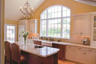 Large elegant single-wall light wood floor eat-in kitchen photo in DC Metro with a farmhouse sink, raised-panel cabinets, white cabinets, granite countertops, white backsplash, subway tile backsplash and an island