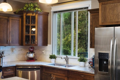 Medium sized traditional l-shaped open plan kitchen in Los Angeles with a double-bowl sink, shaker cabinets, dark wood cabinets, granite worktops, white splashback, metro tiled splashback, stainless steel appliances and an island.