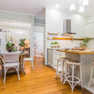 Design ideas for a country l-shaped eat-in kitchen in Brisbane with shaker cabinets, grey cabinets, wood benchtops, stainless steel appliances, medium hardwood floors, with island and brown floor.