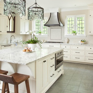 Foto di una grande cucina tradizionale con lavello sottopiano, ante a filo, ante bianche, top in granito, paraspruzzi beige, paraspruzzi con piastrelle in pietra, elettrodomestici da incasso, pavimento con piastrelle in ceramica e isola