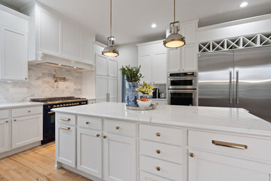 Example of a large trendy kitchen design in Denver with shaker cabinets, white cabinets, white backsplash, an island and white countertops