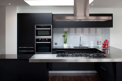Moderne Küche mit integriertem Waschbecken, Edelstahl-Arbeitsplatte und Küchengeräten aus Edelstahl in Hertfordshire
