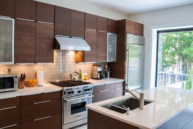Example of a trendy single-wall eat-in kitchen design in New York with an undermount sink, flat-panel cabinets, dark wood cabinets, quartz countertops, white backsplash, glass tile backsplash and stainless steel appliances