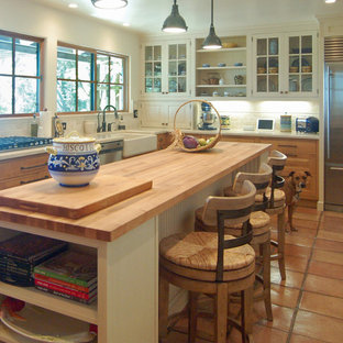 Large mediterranean enclosed kitchen inspiration - Enclosed kitchen - large mediterranean l-shaped terra-cotta tile enclosed kitchen idea in San Luis Obispo with a farmhouse sink, beaded inset cabinets, white cabinets, marble countertops, white backsplash, stone tile backsplash, stainless steel appliances and an island