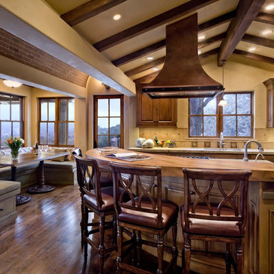 Kitchen - rustic kitchen idea in San Francisco with raised-panel cabinets, dark wood cabinets and beige backsplash