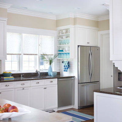 Inspiration for a large timeless l-shaped medium tone wood floor and brown floor kitchen remodel in Chicago with an undermount sink, recessed-panel cabinets, white cabinets, granite countertops, white backsplash, subway tile backsplash, stainless steel appliances and brown countertops
