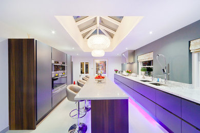 Large contemporary galley enclosed kitchen in Other with a double-bowl sink, flat-panel cabinets, grey cabinets, marble worktops, white splashback, stainless steel appliances, porcelain flooring and an island.