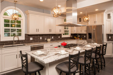 Example of a mid-sized transitional l-shaped ceramic tile eat-in kitchen design in New York with a single-bowl sink, recessed-panel cabinets, white cabinets, solid surface countertops, gray backsplash, glass tile backsplash, stainless steel appliances and an island