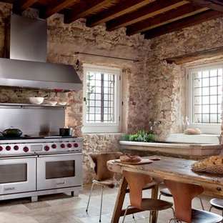 Diseño de cocina lineal, minimalista, de tamaño medio, cerrada, sin isla, con electrodomésticos de acero inoxidable, suelo de pizarra, fregadero integrado, salpicadero beige, salpicadero de azulejos de piedra y suelo beige