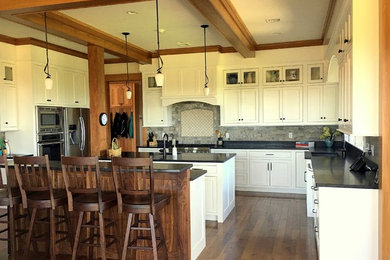 Example of a mid-sized mountain style l-shaped medium tone wood floor open concept kitchen design in Boston with an integrated sink, shaker cabinets, white cabinets, granite countertops, gray backsplash, glass tile backsplash, stainless steel appliances and two islands