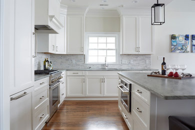 Inspiration for a transitional l-shaped medium tone wood floor and brown floor open concept kitchen remodel in Other with an undermount sink, recessed-panel cabinets, white cabinets, granite countertops, gray backsplash, mosaic tile backsplash, paneled appliances and an island