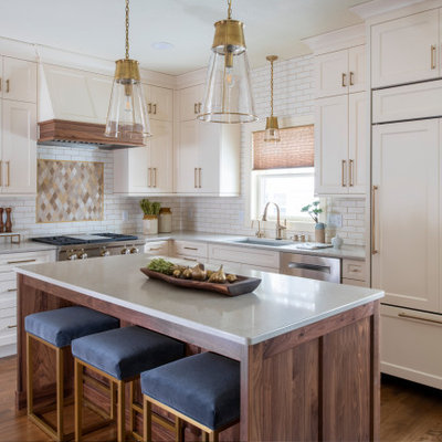 Mid-sized transitional l-shaped medium tone wood floor and brown floor eat-in kitchen photo in Minneapolis with an undermount sink, shaker cabinets, quartz countertops, an island, white cabinets, white backsplash, subway tile backsplash, stainless steel appliances and white countertops