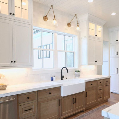 Kitchen - large contemporary l-shaped light wood floor and brown floor kitchen idea in Columbus with a farmhouse sink, shaker cabinets, light wood cabinets, quartz countertops, white backsplash, stone tile backsplash, stainless steel appliances, an island and white countertops
