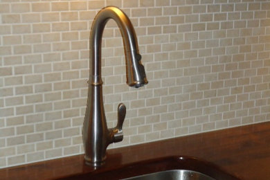 Example of a mid-sized classic l-shaped ceramic tile eat-in kitchen design in Philadelphia with an undermount sink, wood countertops, beige backsplash, ceramic backsplash and no island
