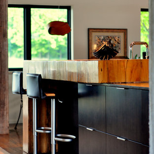 Mid-sized modern open concept kitchen designs - Mid-sized minimalist galley medium tone wood floor and brown floor open concept kitchen photo in Other with a double-bowl sink, flat-panel cabinets, medium tone wood cabinets, stainless steel countertops, gray backsplash, stainless steel appliances, a peninsula and mirror backsplash