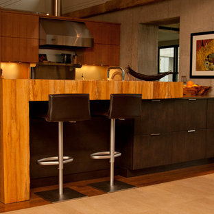 Mid-sized modern open concept kitchen designs - Mid-sized minimalist galley medium tone wood floor and brown floor open concept kitchen photo in Other with a double-bowl sink, flat-panel cabinets, medium tone wood cabinets, stainless steel countertops, gray backsplash, stainless steel appliances, a peninsula and mirror backsplash