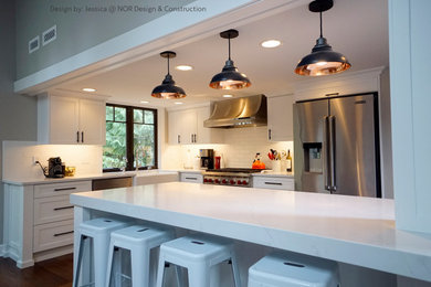 Inspiration for a mid-sized contemporary l-shaped medium tone wood floor and brown floor eat-in kitchen remodel in Seattle with a farmhouse sink, shaker cabinets, white cabinets, quartzite countertops, white backsplash, ceramic backsplash, stainless steel appliances, an island and white countertops