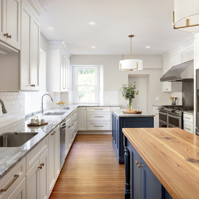 Enclosed kitchen - huge traditional u-shaped medium tone wood floor and brown floor enclosed kitchen idea in DC Metro with an undermount sink, recessed-panel cabinets, white cabinets, white backsplash, stainless steel appliances, two islands, gray countertops, quartzite countertops and ceramic backsplash