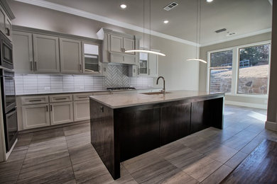 Eat-in kitchen - mid-sized transitional l-shaped porcelain tile and brown floor eat-in kitchen idea in Dallas with an undermount sink, shaker cabinets, gray cabinets, granite countertops, gray backsplash, porcelain backsplash, stainless steel appliances and an island