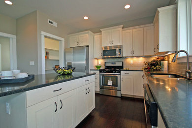 Example of an arts and crafts kitchen design in Other with an undermount sink, white cabinets, granite countertops, stainless steel appliances and an island